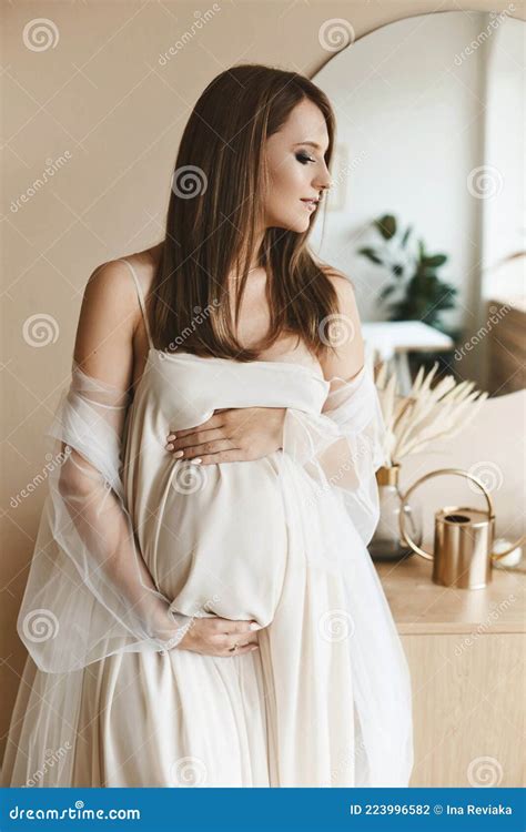 Amazing Beauty Young Pregnant Beautiful Woman Is Standing And Holding Her Belly Looking Aside