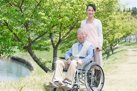 Senior Man Sitting On A Wheelchair With Caregiver Stock Image Image