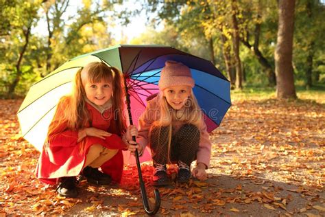 Cute Little Girls With Colorful Umbrella In Autumn Park Stock Photo