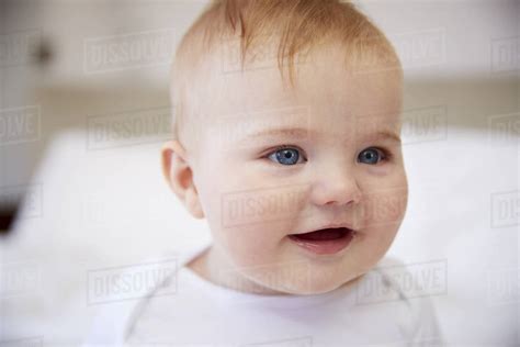 Close Up Of Happy Baby Boy Sitting On Parents Bed Stock Photo Dissolve