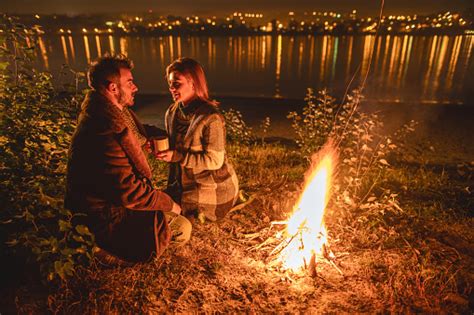 Romantic Couple Communicating By The Bonfire At Night Stock Photo