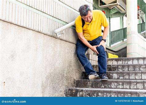 Man With Painful Knee Struggle Walking Down Flight Of Stairs Stock