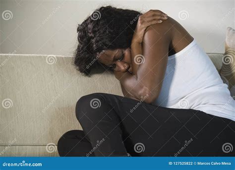 Young Attractive And Sad Black African American Woman Sitting Depressed At Home Sofa Couch