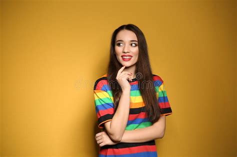 Portrait Of Beautiful Young Woman On Yellow Background Stock Photo
