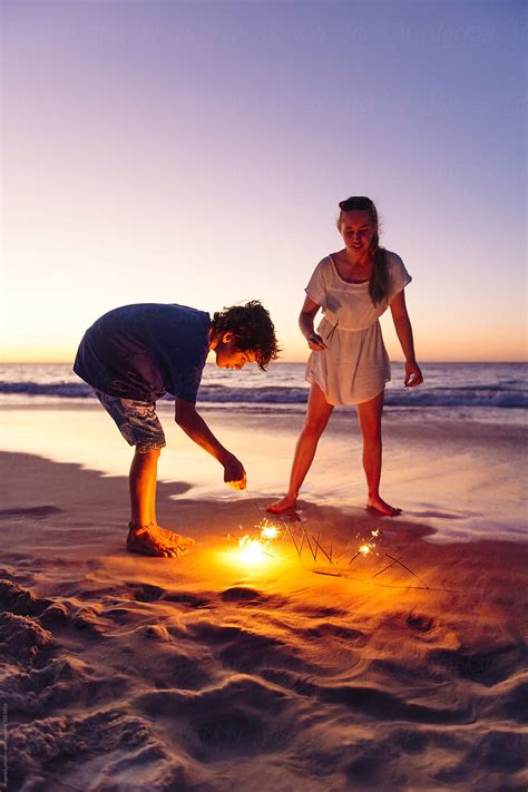 Brother And Sister With Sparklers At The Beach At Night By Stocksy