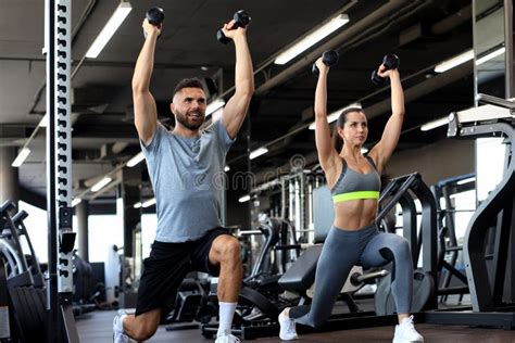 Attractive Sports People Are Working Out With Dumbbells At Gym Stock