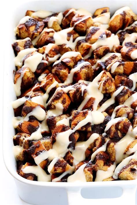 A Casserole Dish Filled With Cinnamon Rolls Covered In White Sauce And