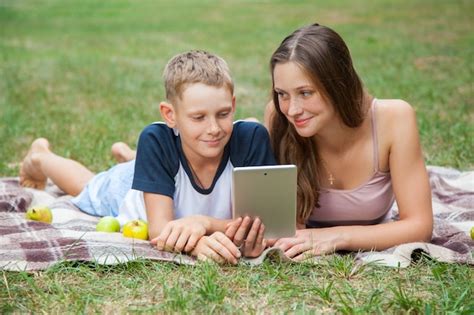 Premium Photo Young Sister And Brother Lying Down And Work With Tablet