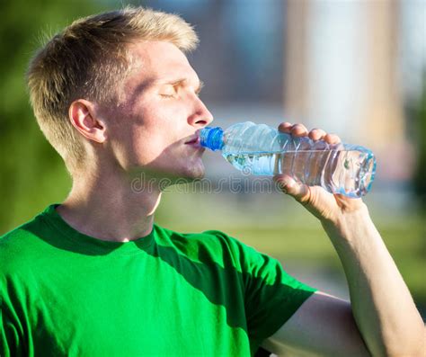 Tired Man Drinking Water From A Plastic Bottle Stock Photo