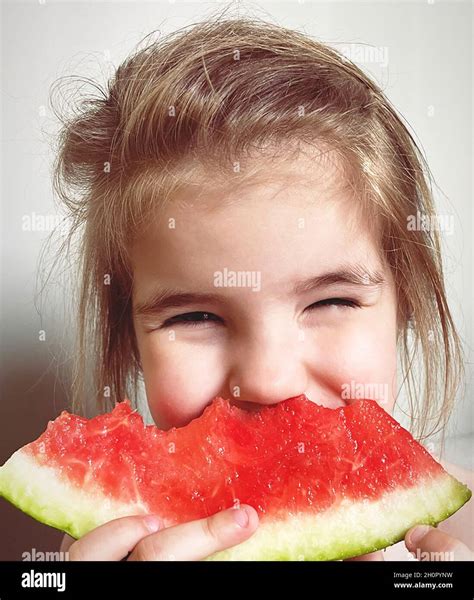 Close Up Portrait Of Happy Cute Little Girl Kid Eating Cut Slice Of
