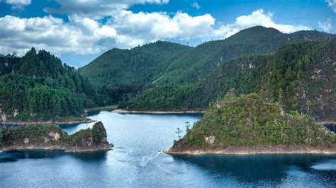 Green Plants Covered Hills In The Middle Of Body Of Water