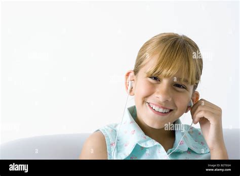 Girl Listening To Earphones Smiling At Camera Stock Photo Alamy