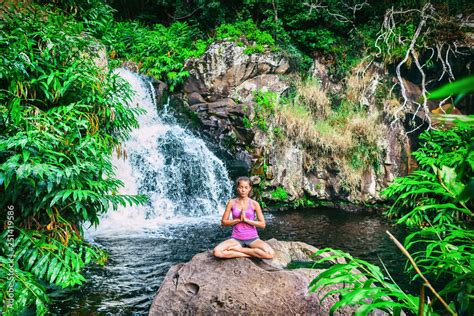 Yoga Retreat Woman Praying Doing The Lotus Pose Meditating At Waterfall Forest In Kauai Hawaii