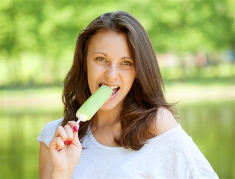 Premium Photo Young Woman Eating Ice Cream Sunny Day Outdoors