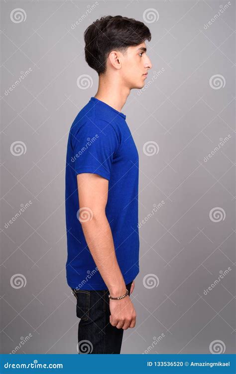 Profile View Of Young Handsome Persian Teenage Boy Against Gray