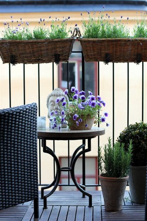 Two Planters With Purple Flowers Are On The Balcony