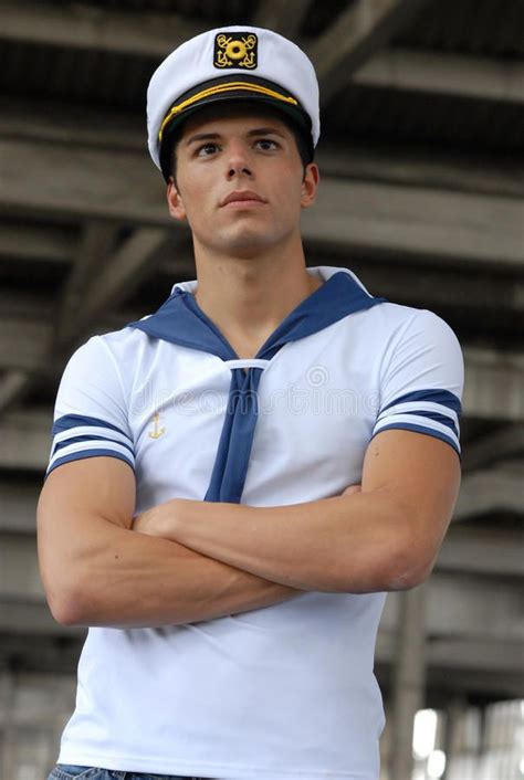 A Man Wearing A Sailors Uniform With His Arms Crossed In Front Of Him