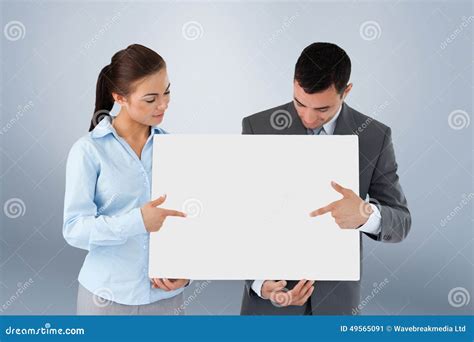Composite Image Of Business Partners Pointing At Sign They Are