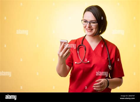 Portrait Of Beautiful Woman Doctor With Stethoscope Wearing Red Scrubs