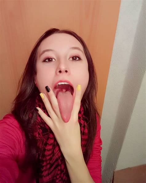 A Woman With Her Mouth Open And Tongue Out Taking A Selfie On Instagram