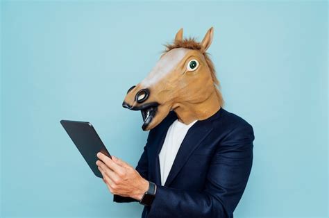 Premium Photo Young Man In Funny Horse Mask Works With A Portable Tablet