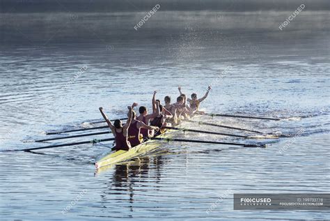 Rowing Team Celebrating In Scull On Lake — Olympic Oars Stock Photo