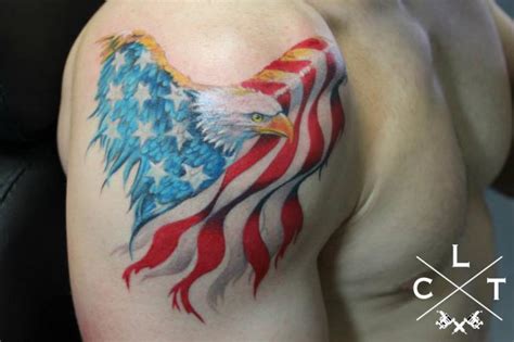 A mirrored image of a stalking bird on each shoulder creates symmetry in the piece. Shoulder Eagle Usa Flag Tattoo by Cesar Lopez Tattoo
