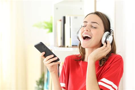 Happy Teen Singing Listening To Music On Phone At Home Stock Image