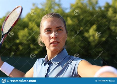 Beautiful Tennis Player Serving The Ball On The Tennis Court Stock