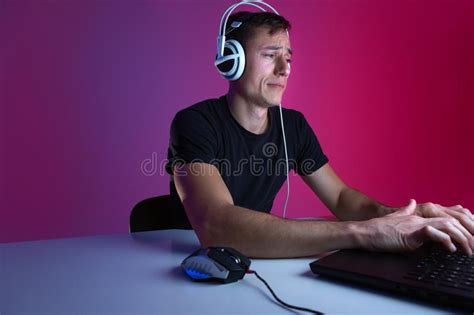 Angry Gamer Wearing Headphones Playing Video Games On Computer In A