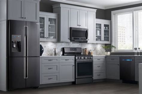 The smooth wholesale light grey cabinets finish on this modern design is a reliable choice for both contemporary and classic aesthetics, opening up kitchen space and complementing a variety of countertops and appliances. Samsung's Black Slate appliances with gray cabinets ...