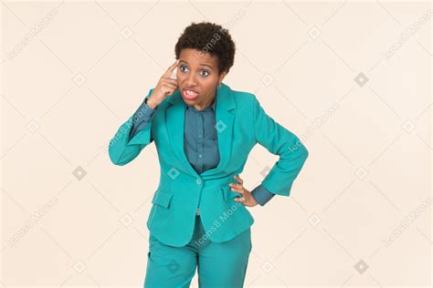 fotos de mulher negra com um corte de cabelo curto vestindo todo o azul de pé contra um fundo