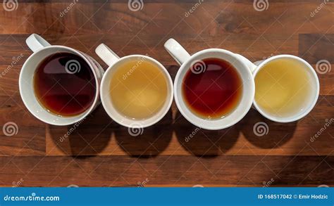 Top View Of Colorful Teas Filled In White Cups And Placed On Wooden