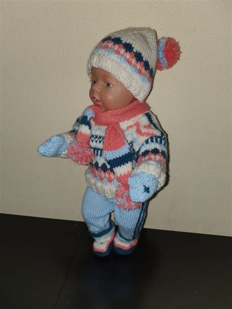 A Small Doll Is Wearing A Sweater And Hat