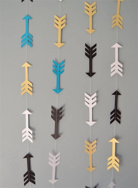 A Group Of Paper Arrows Hanging From The Side Of A Wall In Different