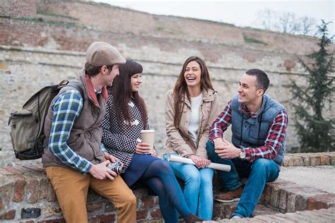 Group Of Friends Sitting And Laughing By Stocksy Contributor Mosuno