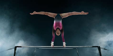 Female Gymnast Doing A Complicated Trick On Gymnastic Horizontal Bar
