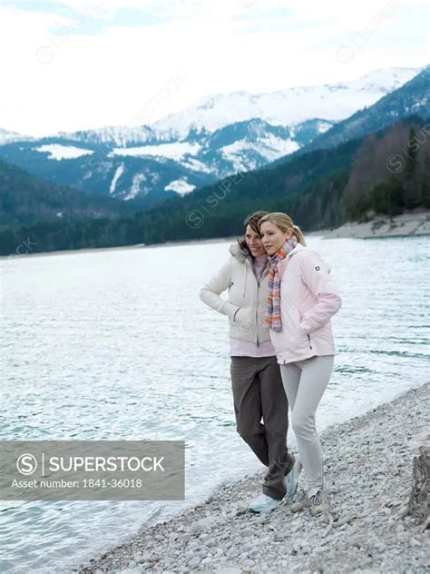Two Babe Women Standing At Riverbank And Smiling SuperStock