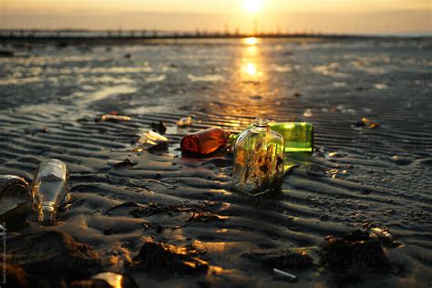 Sunset Rays Passing Through Old Glass Bottles On The Beach By Stocksy