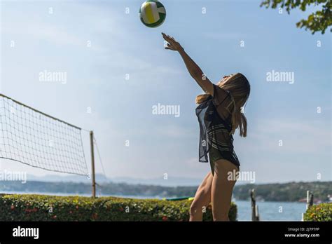 Young Latin Girl Playing Volley Ball Throwing The Ball At A Lake Stock