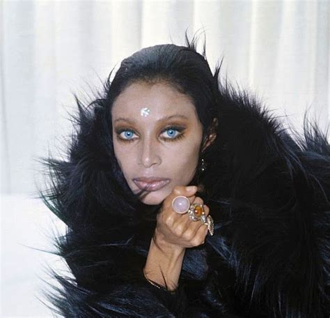 a woman with blue eyes and black fur coat