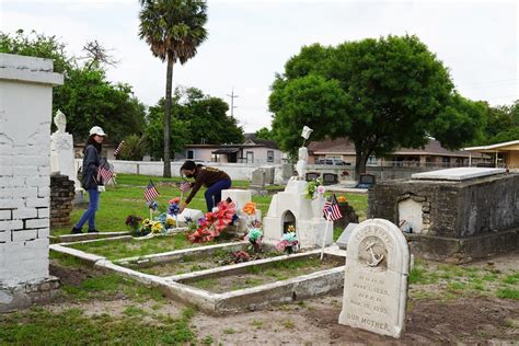 Volunteers place flags by gravesides of veterans at Brownsville’s Old