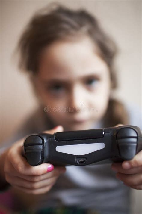 Little Girl Holds A Joystick And Plays A Game Console Stock Image