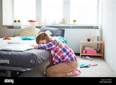 Sad Teen Girl Sitting On Carpet In Her Cozy Bedroom Alone And Crying