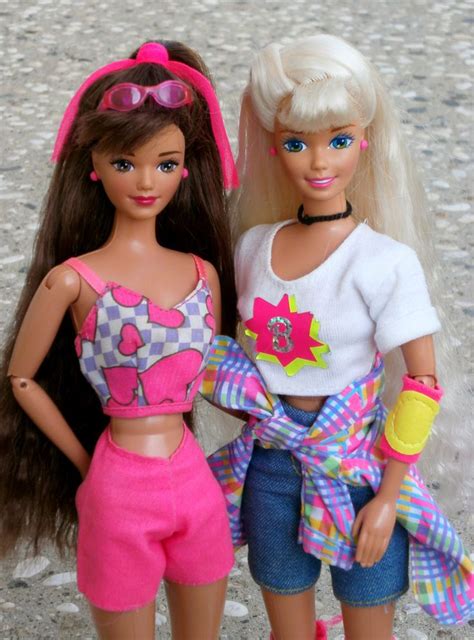 Two Barbie Dolls Standing Next To Each Other