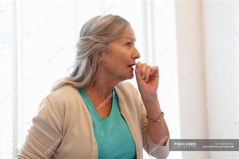 Older Woman Coughing Into Her Hand — Head And Shoulders One Person
