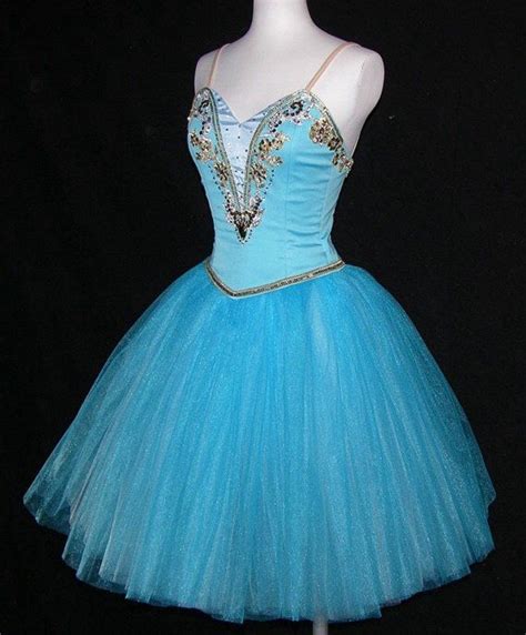 A Blue Dress With Gold Sequins And Beads On The Bust Sitting On A Mannequin