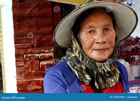 An Adult Filipino Woman Sitting On A Sidewalk Pose For The Camera Editorial Photo