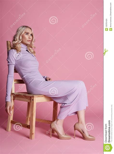 Fashion Beautiful Blonde Woman In Knitted Closed Long Dress Sitting On