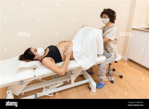 Gynecologist Examining And Performing Pelvic Floor Treatment On Pregnant Caucasian Woman Stock